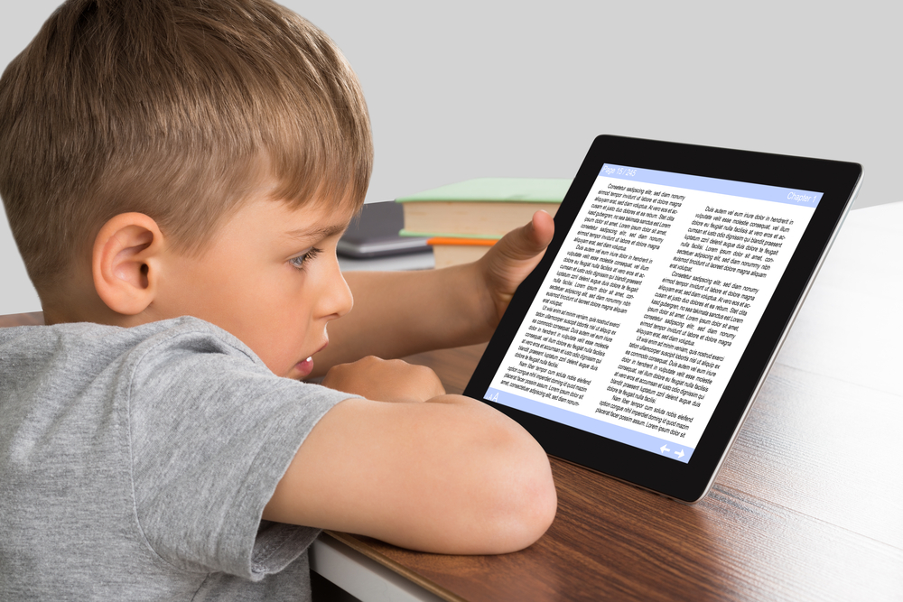 Kid learning to read on ipad Young child learning to read on an IPad